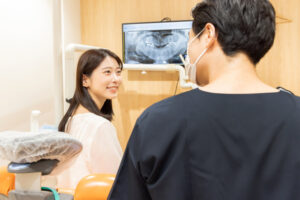 笑顔で歯科医師と話している女性の患者様の写真