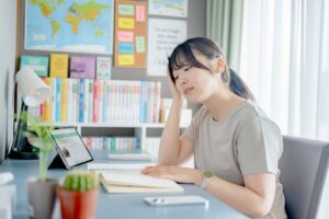 調べごとに集中している女性が顎の違和感を感じている写真